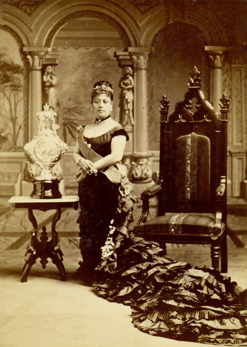 Portrait of Queen Emma with throne and the silver christening cup gifted by Queen Victoria of England to the Prince of Hawai‘i; Honolulu, Hawai‘i. Photo by J.J. Williams, 1870-1888. Call Number: SP_38913 Image from Bishop Museum Archives, Honolulu, Hawaii. Images are not to be re-used without permission.
