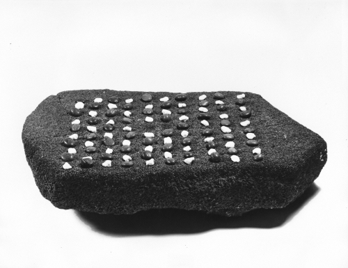 Konane game stone, used for playing konane, a game similar to checkers using black and white stones placed in depressions where two players proceed by jumping stones, Hawai‘i. n.d. Photographer: University of Hawai‘i Committee for the Preservation of Hawaiian Language and Culture. Call Number: Hawaiian Cultural Photos, book 7, pg. 5. Image from Bishop Museum Archives, Honolulu, Hawaii. Images are not to be re-used without permission.