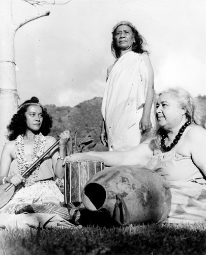 Left to right: ‘Iolani Luahine, Malia Kau (standing) and Mary Kawena Pukui at Hānaiakamalama (Queen Emma's Summer Palace)Nu‘uanu, Honolulu, Hawai‘i. Call Number: People. Bishop Museum Staff. Pukui. [SP 86368] Accession Number: 1983.245 Image from Bishop Museum Archives, Honolulu, Hawaii. Images are not to be re-used without permission.
