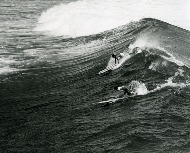 Two surfers in the 1960's. Photo by Laurence Hata. Collection: Laurence Hata Collection Call Number: Hata. Recreation. Sports. Surfing. Image from Bishop Museum Archives, Honolulu, Hawaii. Images are not to be re-used without permission.