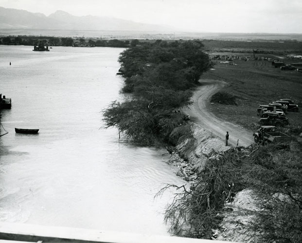 During World War II, the Army and Navy were empowered to take control of whatever land they chose. This sometimes happened simply by men arriving with no warning to move in, but more frequently was handled by signing leases. In other cases, however, land was condemned and owners were compelled to sell. One example of this process was the Waipi‘o Peninsula in Pearl Harbor, shown in this photo. The U.S. Navy condemned this land from its owner, the John I‘i Estate, forcing the disinterment of the remains of this famous Hawaiian historian of the 19th century from the family cemeter Call Number: 1975.113, folder 1 Artifact Number: CP_96432 Location: Bishop Museum Archives Image from Bishop Museum Archives, Honolulu, Hawaii. Images are not to be re-used without permission.