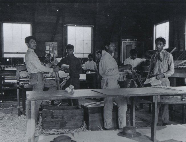 Lahainaluna seminary workshop, mechanical printing press and movable type in type case in background, ca. 1895. Call Number: SP 77272 Accession Number: 1979.544 Image from Bishop Museum Archives, Honolulu, Hawaii. Images are not to be re-used without permission.